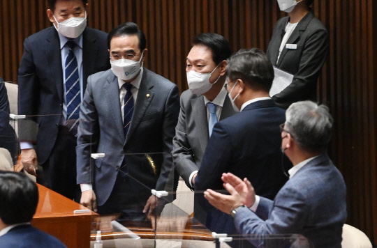 윤석열 대통령이 16일 국회에서 열린 본회의에서 코로나19 손실보상을 위한 추가경정예산(추경)안에 대한 시정연설을 하기 위해 입장하며 더불어민주당 의원들과 인사를 나누고 있다. 공동취재=연합뉴스